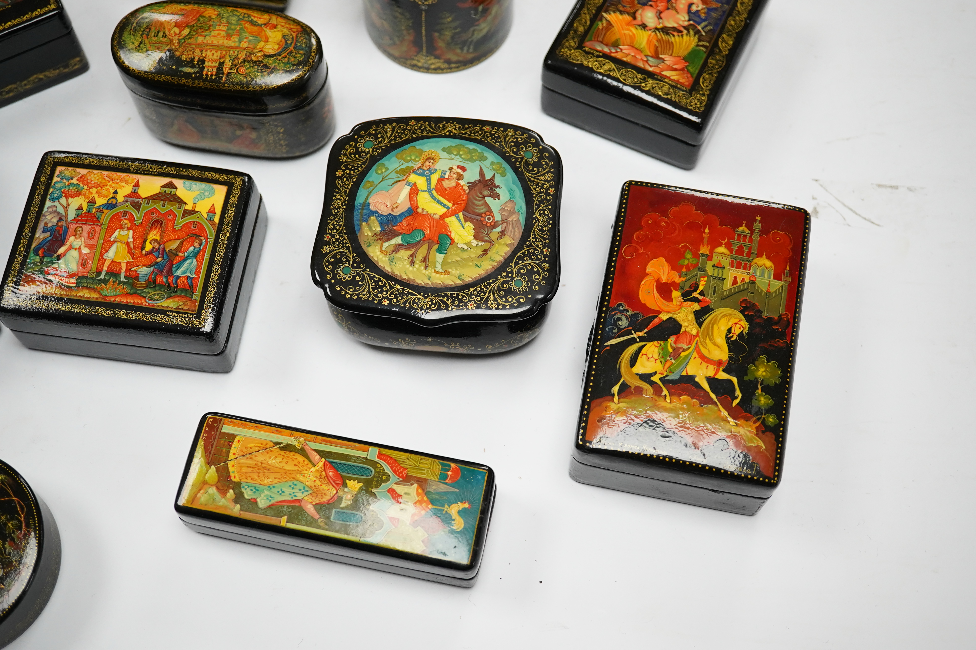 A quantity of Russian lacquer boxes decorated with figures and mythical scenes, largest 10cm in length. Condition - mostly good